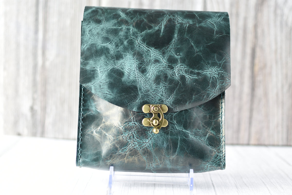 Green marbled purse with a gold clasp on a white background