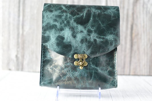 Green marbled purse with a gold clasp on a white background
