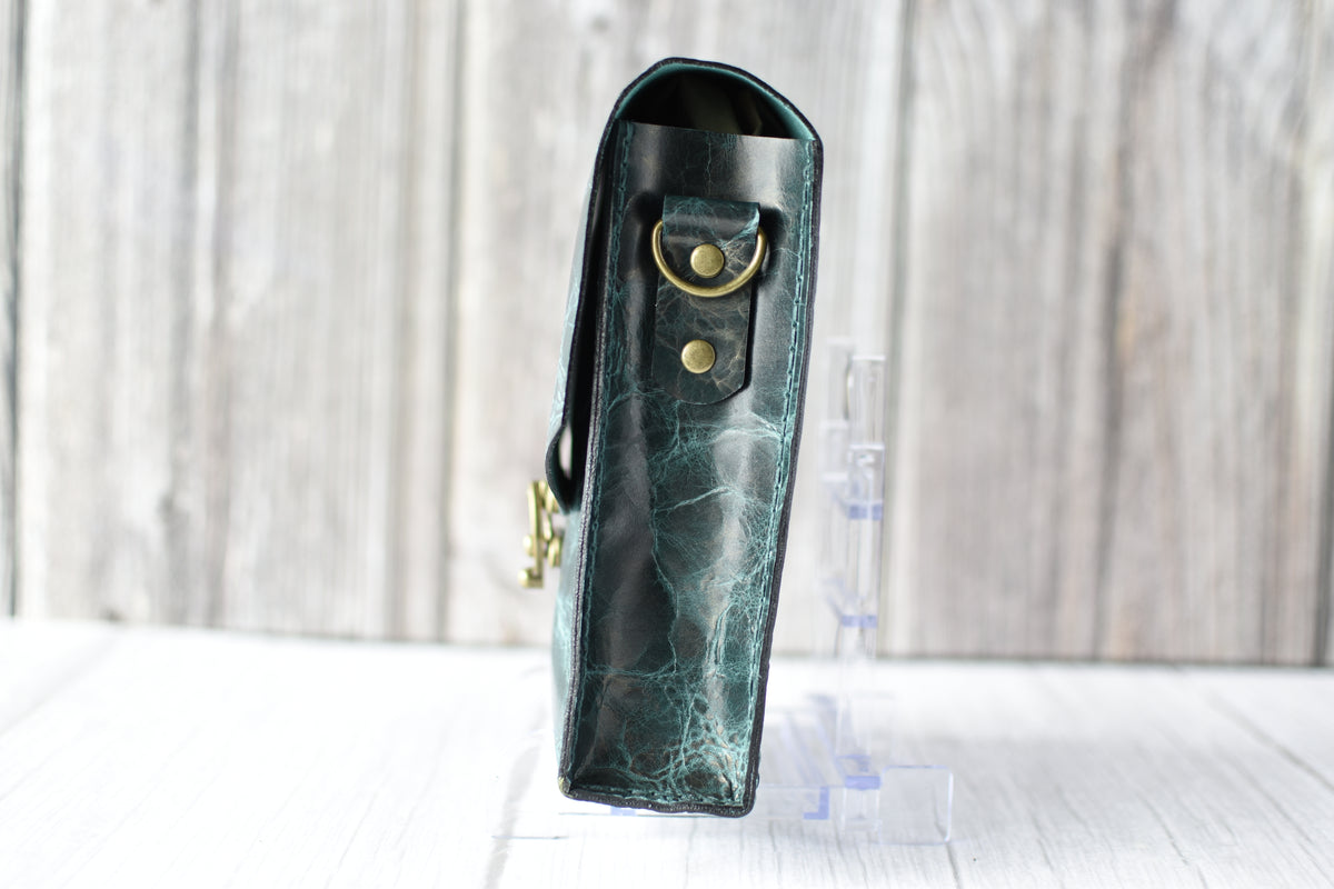 Green marbled purse with a gold clasp on a white background