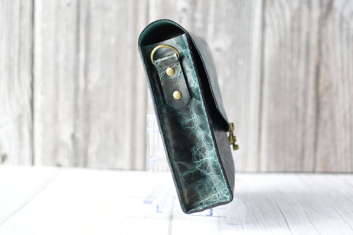 Green marbled purse with a gold clasp on a white background