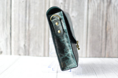 Green marbled purse with a gold clasp on a white background