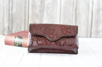 Deep Red leather cell phone purse with embossed design on a white surface