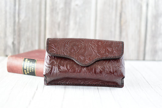 Deep Red leather cell phone purse with embossed design on a white surface